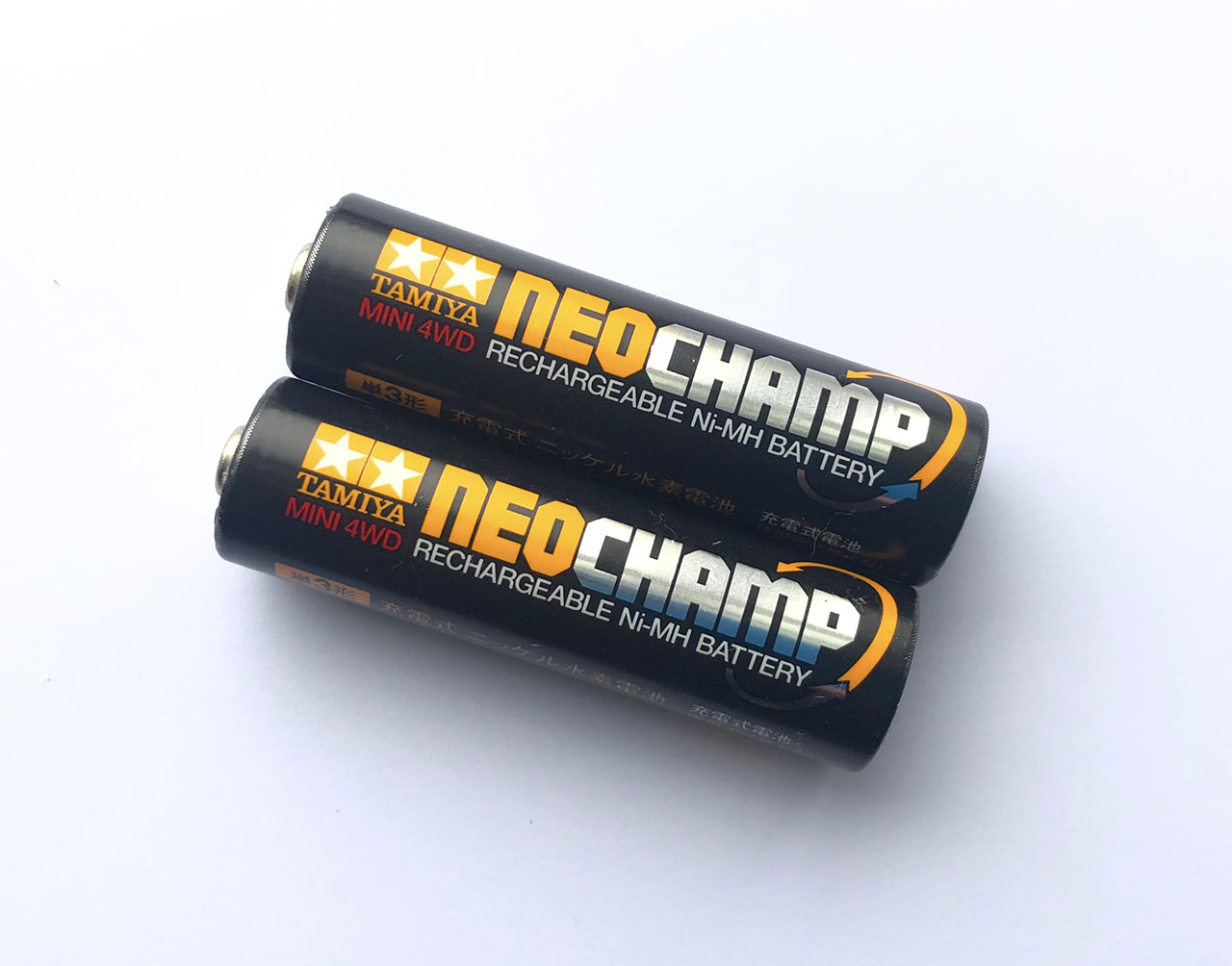 A pair of Tamiya Neo Champ rechargeable 950mAh batteries on a plain white background