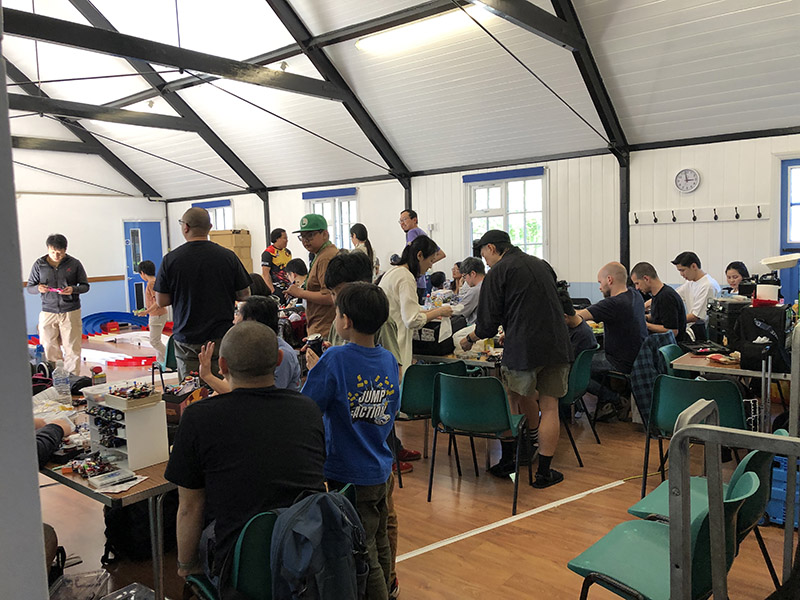 A view from the back, showing people tweaking and practicing at the Mini 4WD B-MAX GP London May 2025 event,