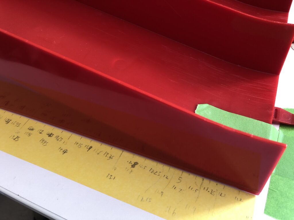 Mapping Tamiya slope jump section with track part stuck down and scribbling measurements down on a masking tape